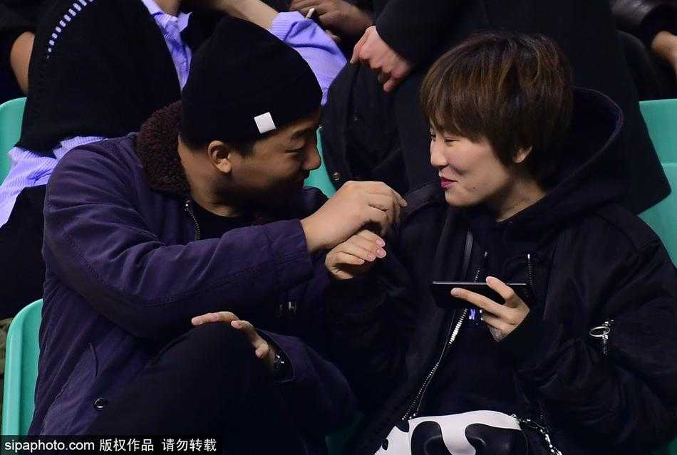 情绪平复后的两人手牵着手，女孩脸上洋溢着幸福的笑容，她侧头靠在男友肩膀上，两人的背影融入了身后潮水般欢呼的辽宁球迷方阵中。