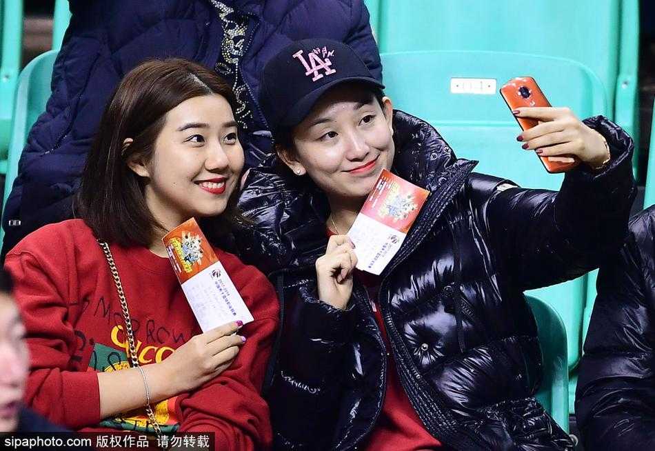 在辽宁队一次成功的防守后，这位穿着毛茸茸外套的可爱女球迷激动地举起双手，脸上绽放出灿烂的笑容，仿佛是自己投中了制胜一球般开心。