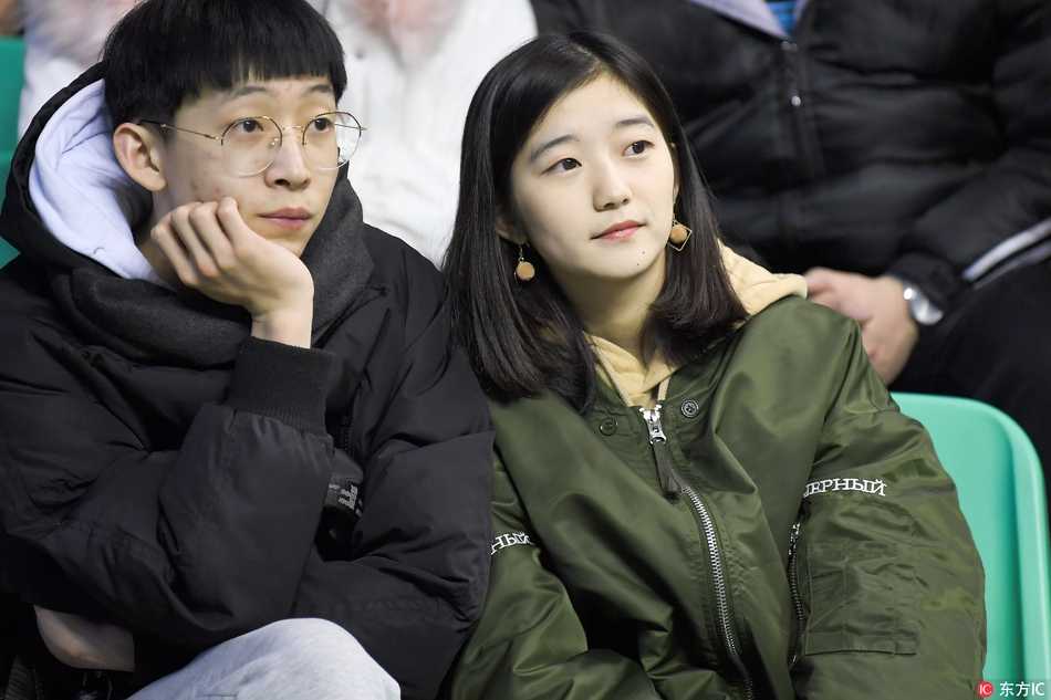 几名青春靓丽的女球迷在看台上合影留念，她们身后的电子大屏幕还显示着辽宁队获胜的比分，记录下了这美好的瞬间。