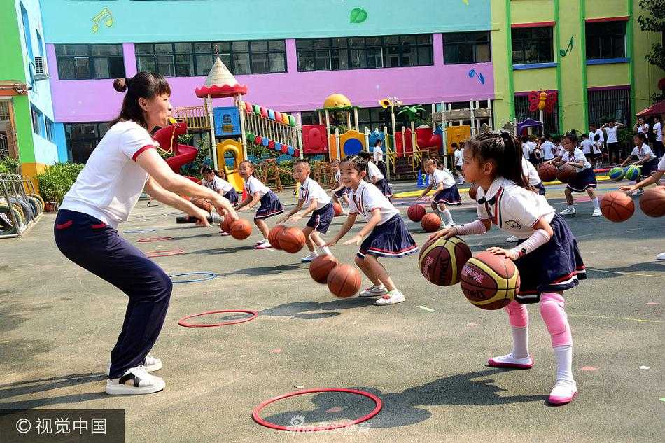 伴随着动感音乐，孩子们同时将手中的篮球高高抛起，在空中划出一道道整齐优美的弧线