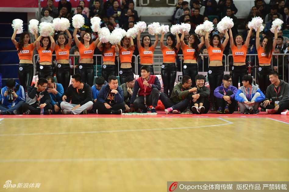 在灯光聚焦的球场中央，女孩们摆出整齐的队形，双手指向前方，仿佛在为球队指明胜利的方向，动感的姿态充满了青春的张力。