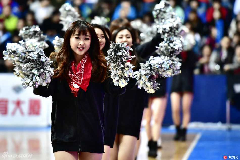 伴随着劲爆的舞曲，一名拉拉队员在聚光灯下展现出自信的微笑，身后队友们整齐划一的动作，共同构成了赛场上一幅充满青春活力的画面。