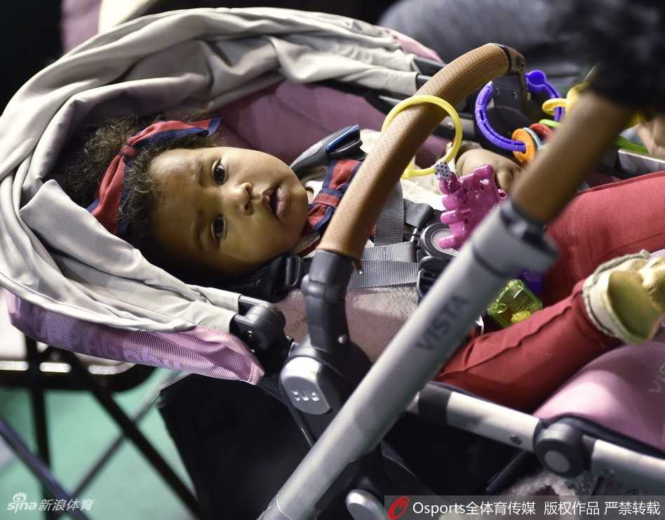 在辽宁主场明亮的灯光下，巴斯的小宝贝趴在围栏上好奇张望，身旁的母亲神情专注，仿佛在嘈杂的球馆里能听见丈夫在场上呼吸的声音。