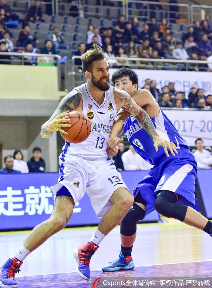 江苏队老将易立持球加速突破，他的身影矫健如风，虽然不再年轻，但每一次冲击篮筐都带着必胜的决心和领袖的担当。