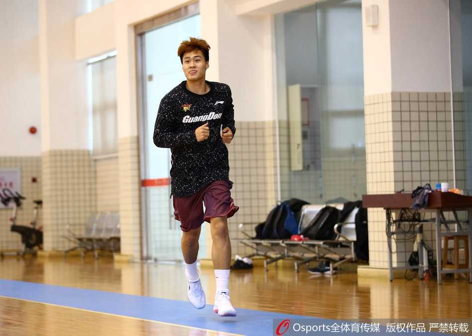 莫里斯身穿广东宏远训练服，在赛前热身中神情专注，拉伸筋骨，为即将到来的首秀做最后准备。