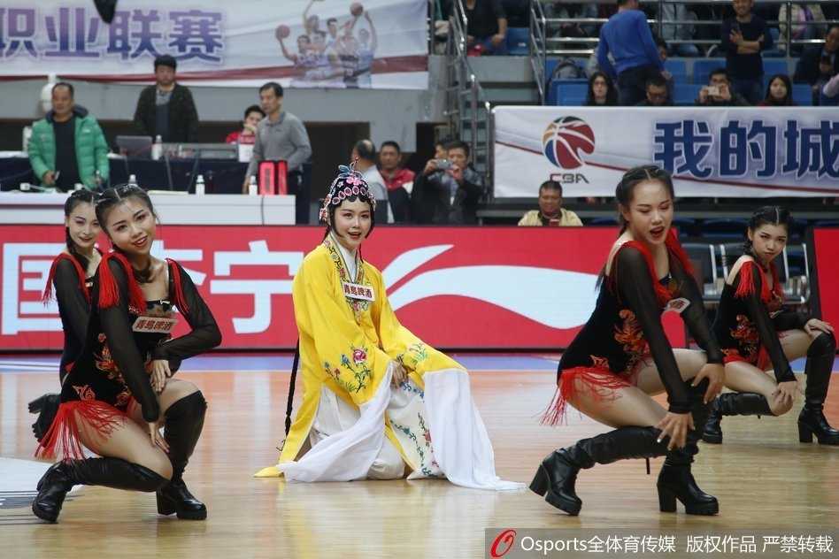 几位篮球宝贝身着华丽戏曲服饰，头戴精美头面，在球场中央摆出戏曲亮相身段，身后的观众席座无虚席，传统与时尚在此刻交汇。