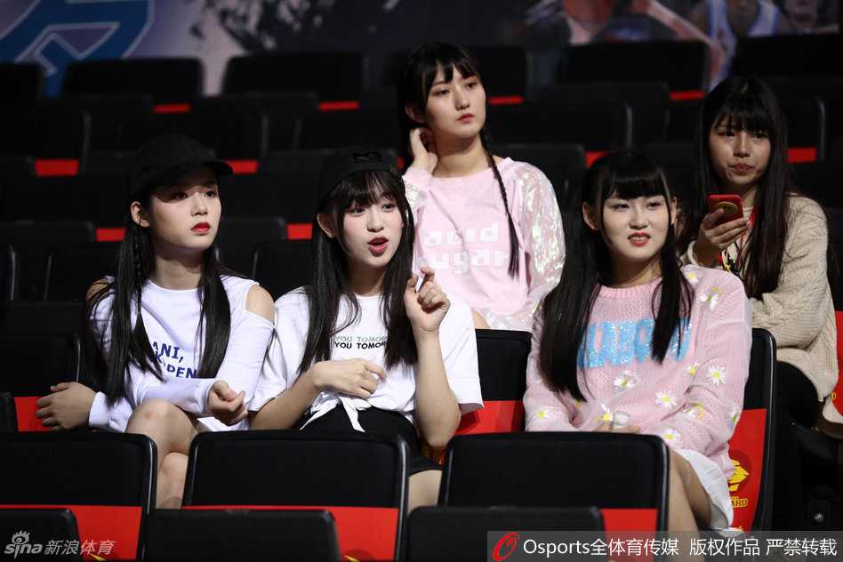 大合照时间！女孩们围聚在一起，对着镜头比出可爱的姿势，身后巨大的CBA赛场背景板记录下这场青春与体育的美丽邂逅。