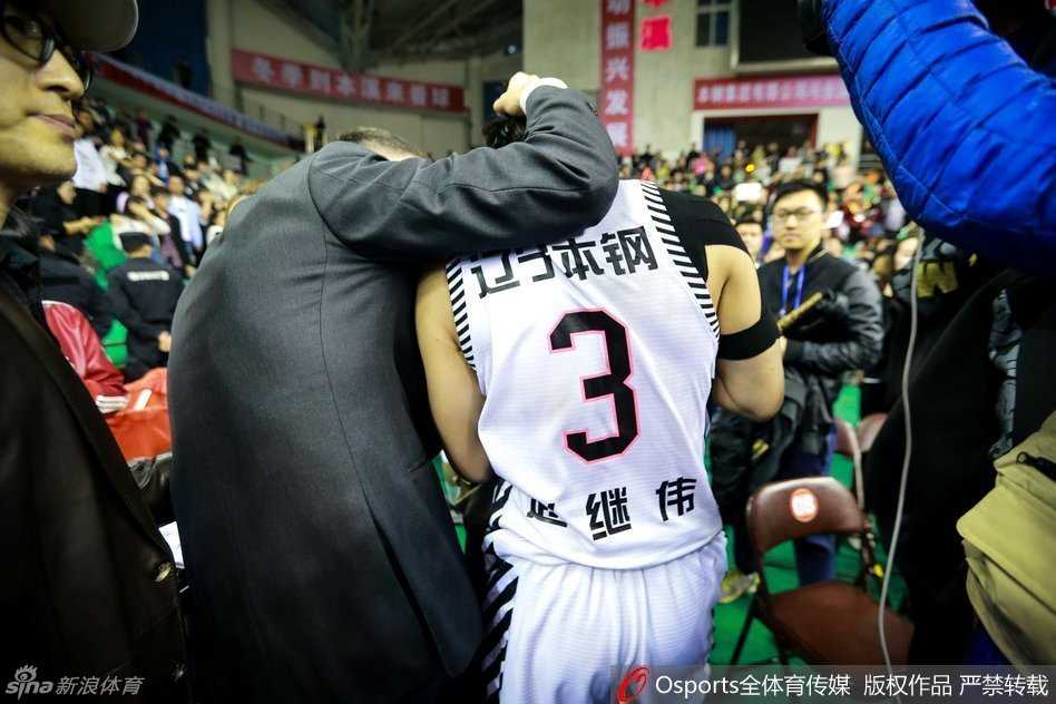 郭艾伦身着便装难掩失落，他神情凝重地望向球场，对于自己无法出战关键比赛感到深深的自责与无奈