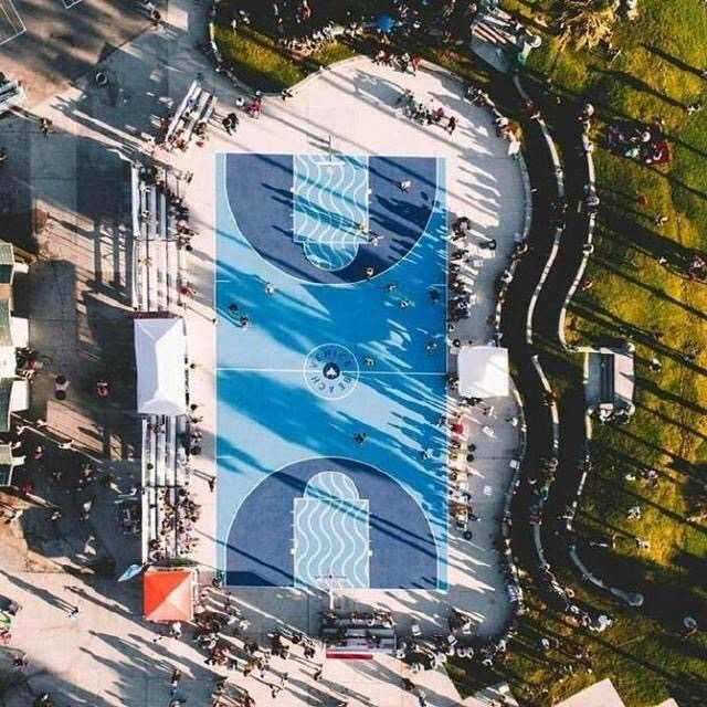 海边的渐变色篮球场，蓝色从浅至深，仿佛与天空海水连成一线