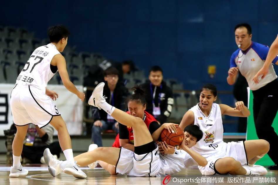 新疆女篮队员们在主场璀璨的灯光下蓄势待发，眼神中闪烁着对胜利的渴望