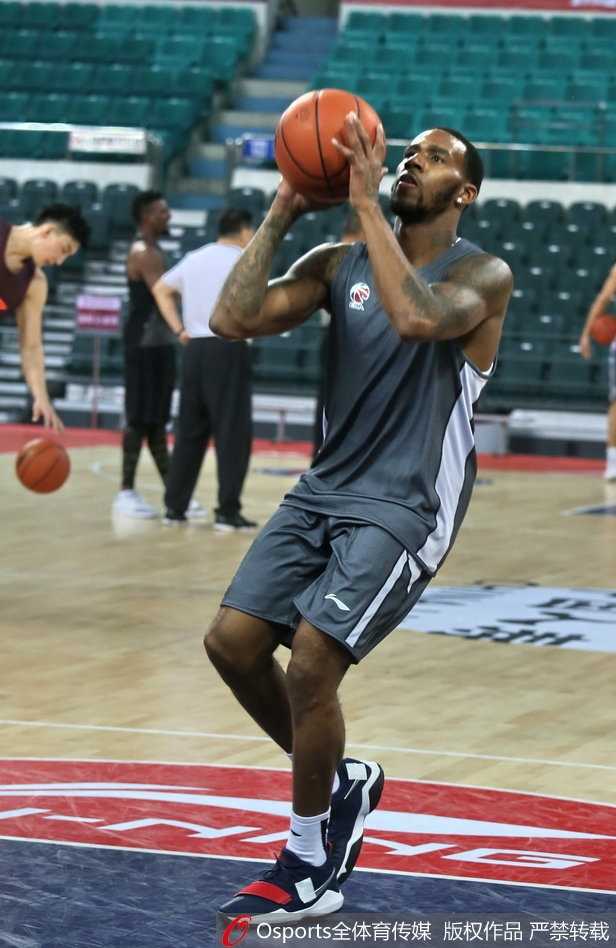 崔万军指导双手比划着战术动作，表情严肃认真，西热力江则双手扶膝，像个虚心受教的学生，两人之间无声的默契仿佛让整个训练场的喧嚣都静止了。