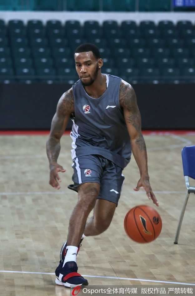 训练馆内灯光如昼，西热力江身着训练服，身体微微前倾，全神贯注地倾听身旁崔万军指导的战术部署，眼神里满是当年那个追风少年的影子。