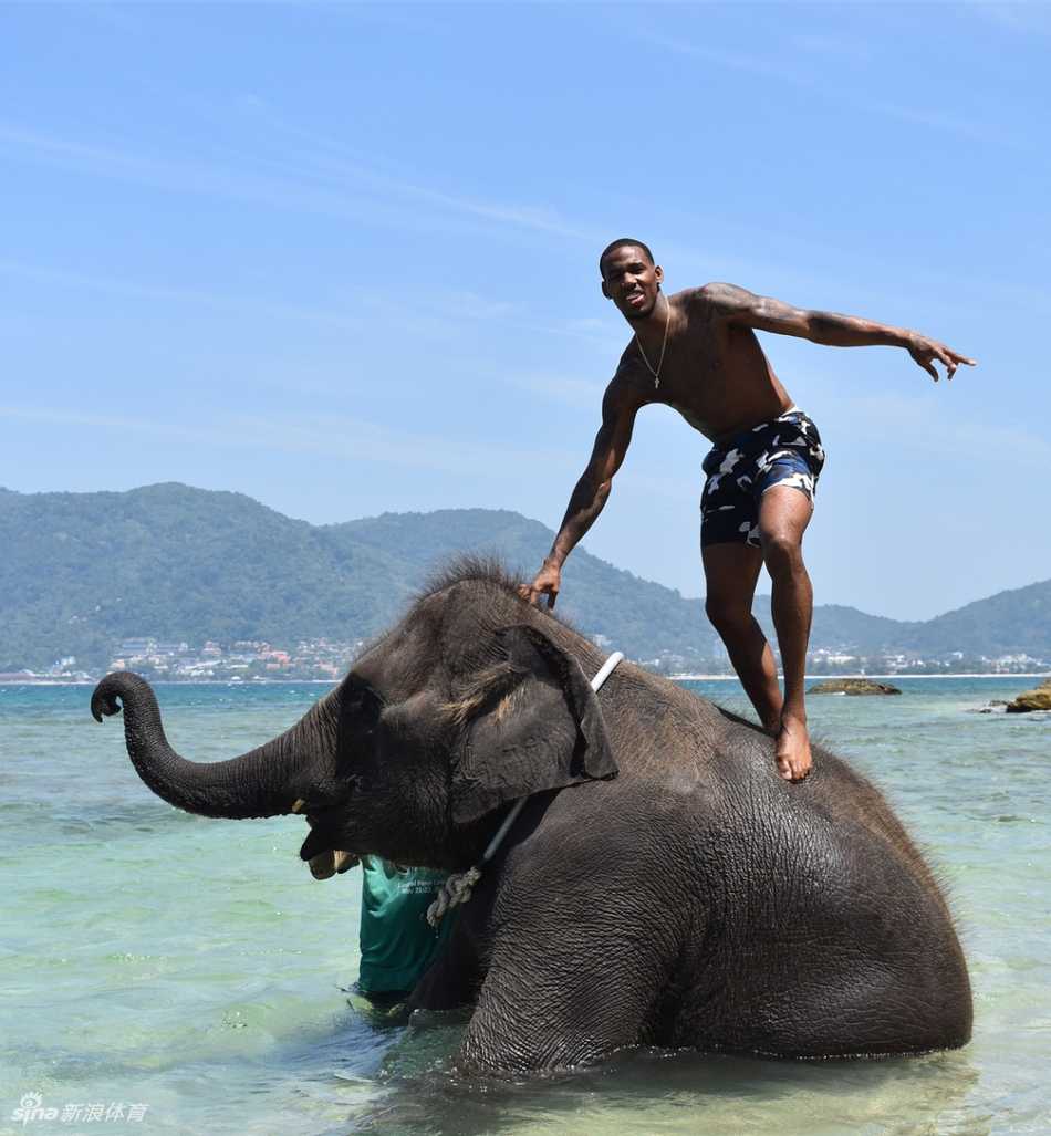 度假中的亚当斯正在品尝当地的特色美食，他专注地看着手中的食物，表情好奇而满足，仿佛在通过味蕾深度体验这个国家的文化。