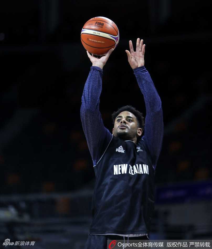 新西兰男篮队员在体能教练指导下进行核心力量训练，汗水浸湿球衣，神情专注而坚毅。