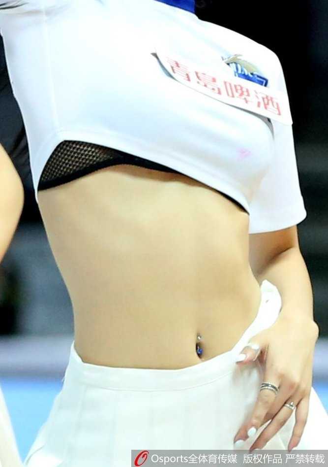 一位篮球宝贝在表演间隙整理秀发，随性的动作中透露出优雅，背后是模糊的看台人潮，这一刻仿佛喧嚣中的宁静，充满了故事感。