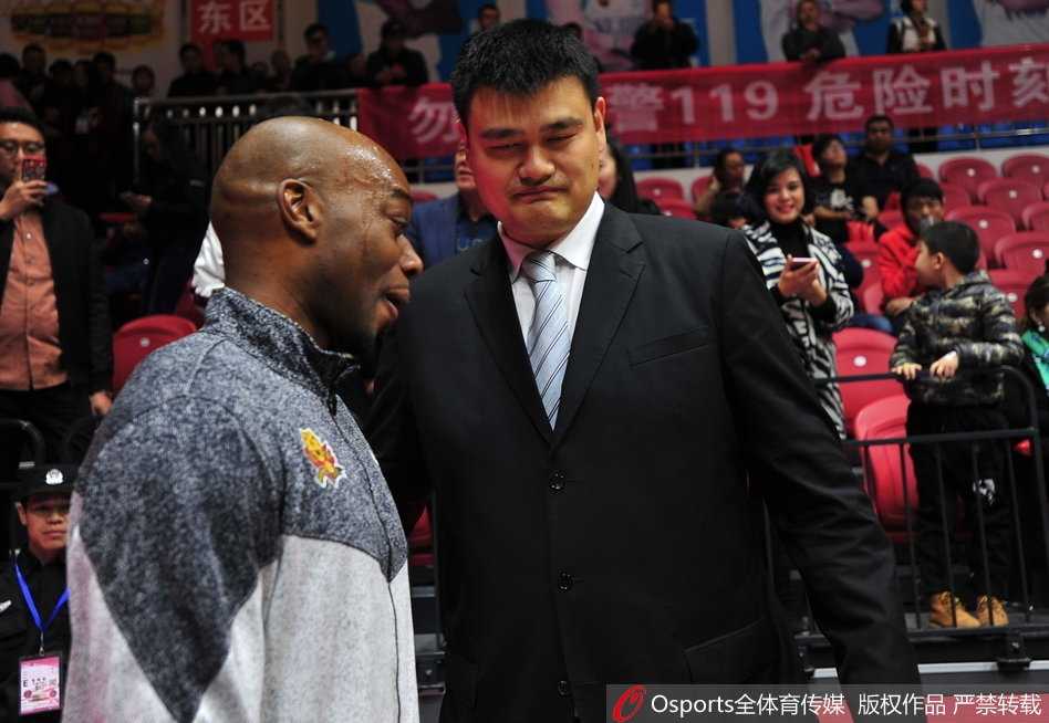 兰德里伸出手与姚明握手致意，姚明也伸手回应，两人目光交汇，一个握手传递的是多年未变的尊重与友谊，仿佛时间并未走远。