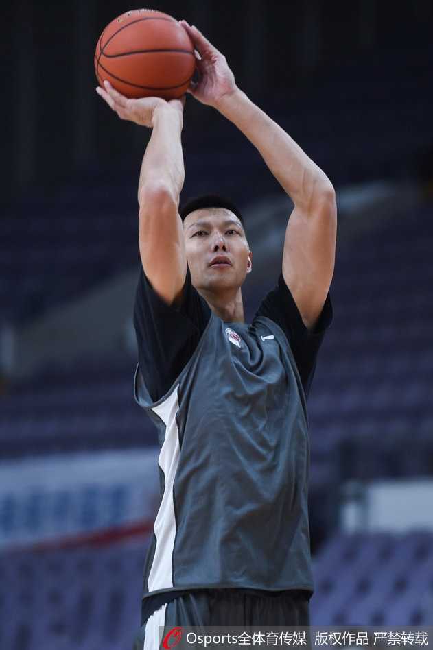 易建联神情专注，在训练师陪同下进行中距离投篮练习，皮球划出优美弧线稳稳入网。