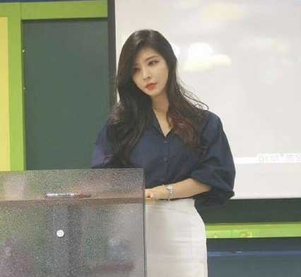 老师站在讲台前，拿起粉笔，脸上带着一丝狡黠的微笑，准备把翘课学生的模样画下来