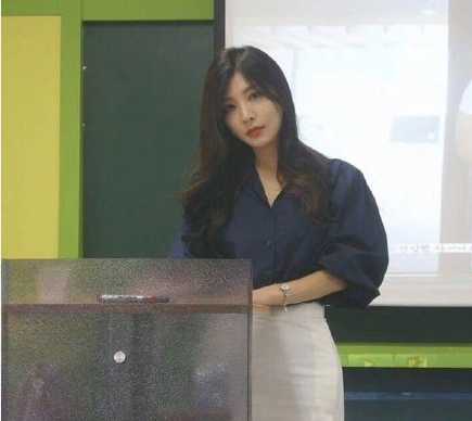 教室里充满了欢快的氛围，同学们看着黑板上的画作，有的捂着嘴笑，有的拿出手机拍照，课堂气氛轻松活泼