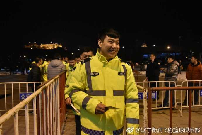 辽篮球迷与公安干警在看台上共同为球队加油，球迷脸上画着油彩，干警们则挥舞着手中的助威棒，警民同乐的画面温馨而充满活力