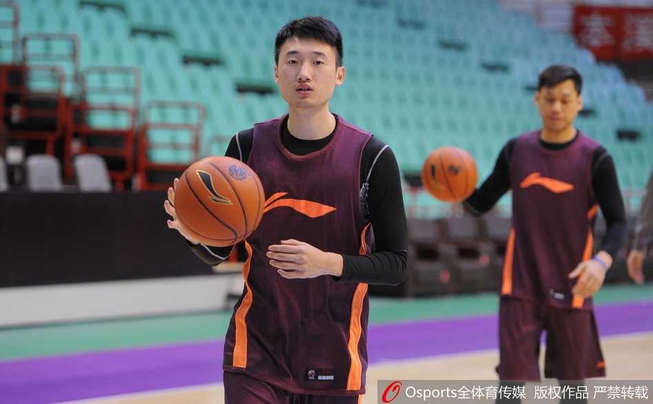 李春江指导双手持球，身体微微下蹲，正准备将球传给切入的队员，战术手势清晰明了，指挥若定。