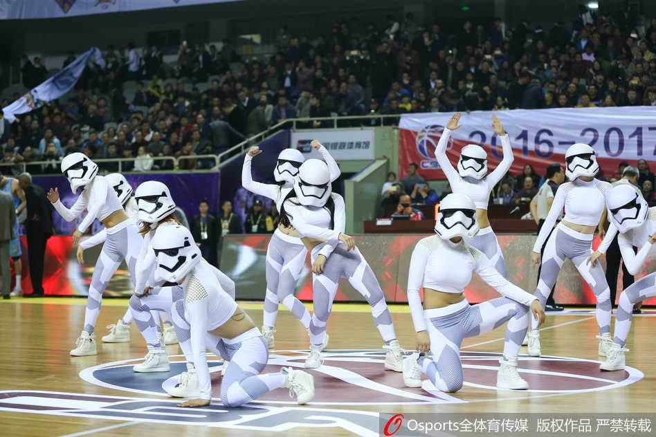 特写镜头下，篮球宝贝的星际战士头盔反射出球场的灯光，她正在为江苏队的精彩进攻振臂欢呼。