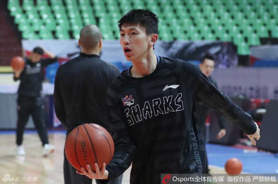 内线大将张兆旭正在场边认真地拉伸腿部肌肉，为了守护球队的禁区，他必须时刻保持身体处于最佳状态。