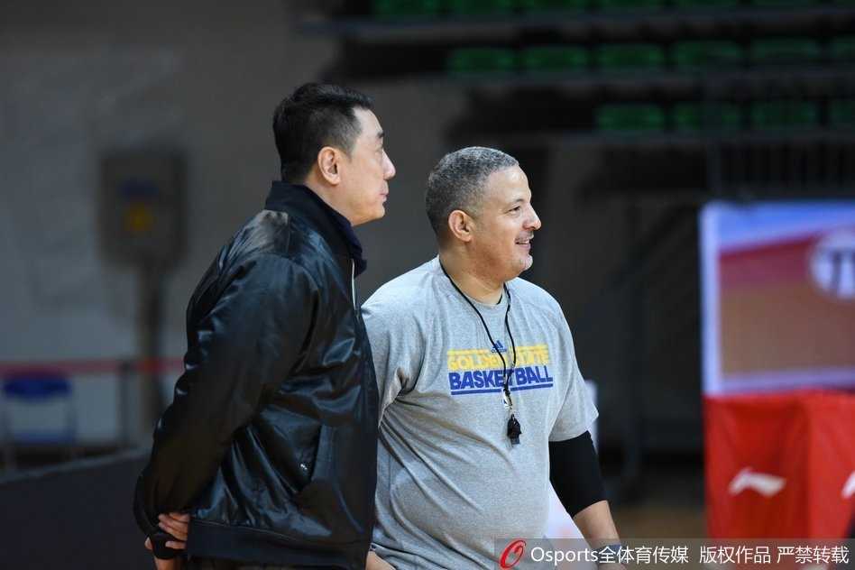 王非与休利并肩而立，目光如炬地注视着场上的训练，两位老友的默契在无声中传递。