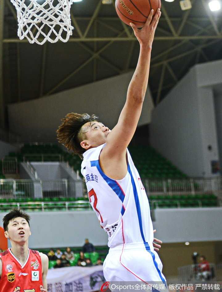 天津队与八一队的球员们在篮下乱作一团，数双手臂同时伸向空中的皮球，拼抢激烈至极。