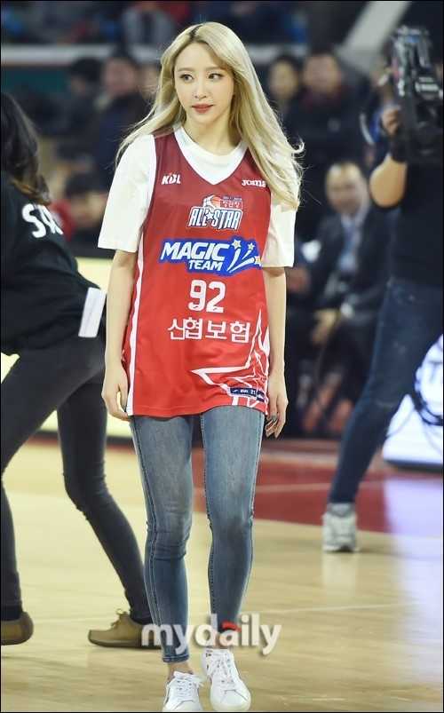 Hani与正花并排站在球场边线，两人身穿印有专属名字的球衣，手中拿着篮球相视而笑，眼神中流露出即将上场的兴奋与独有的姐妹情深。