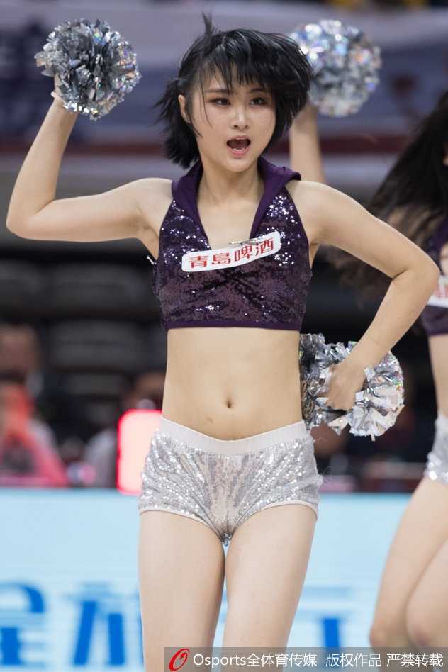 灯光聚焦于舞台中央，领舞的宝贝高举双手，带领身后的团队共同演绎一段高潮舞步，她们身后的巨幅海报映衬出浓烈的比赛氛围。