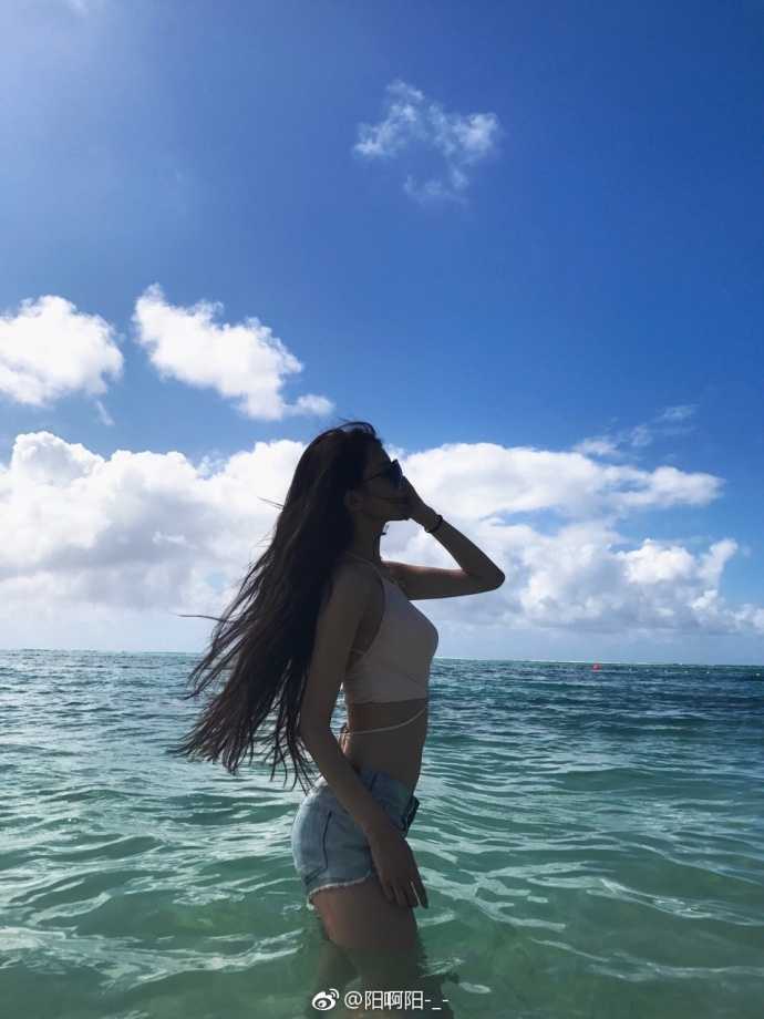 特写镜头下，马阳阳的五官精致立体，脸上带着浅浅的笑意，海水的泡沫轻轻环绕，让她看起来充满了青春的活力与纯真。