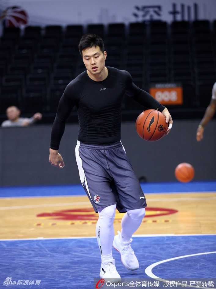 主教练正拿着战术板蹲在地上给球员讲解跑位，队员们围成一圈神情专注，仿佛战场上的将军在排兵布阵。