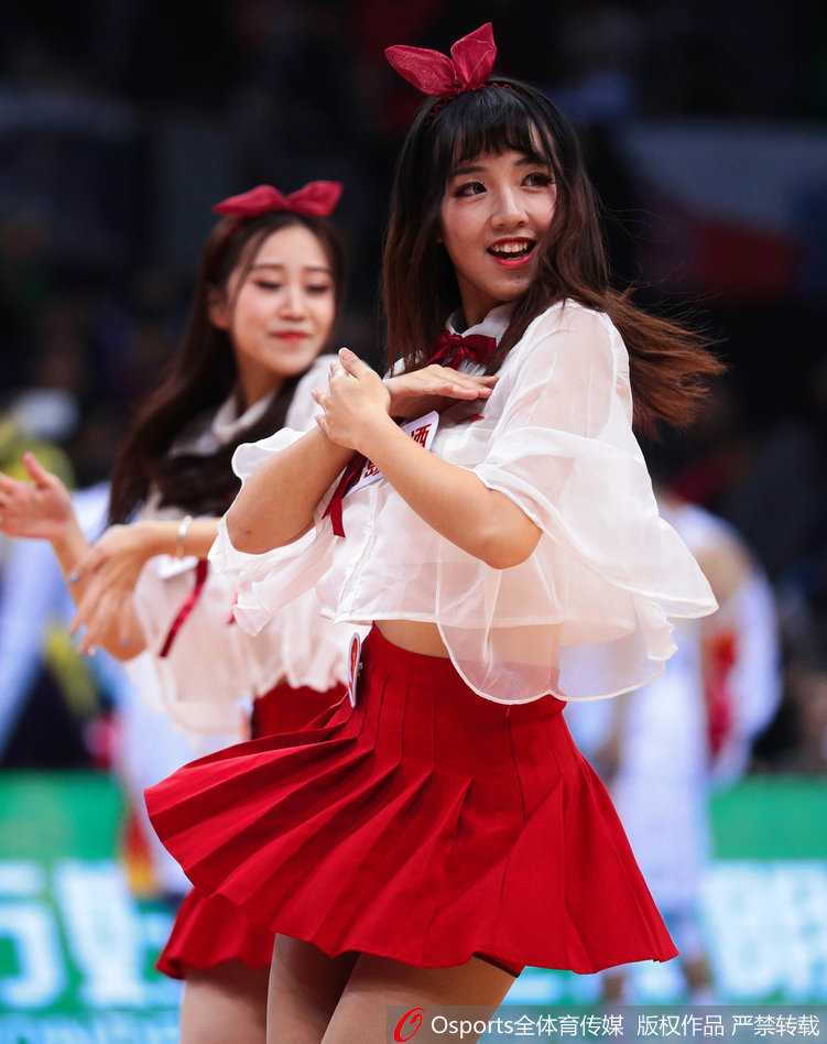 集体造型中，宝贝们错落有致地摆出优美姿态，红色的裙装在灯光下格外耀眼，她们的身姿与手中的花球构成一幅充满美感的画面。