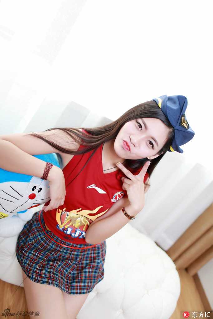 她迈着轻盈的步伐向前走来，手中的玩偶仿佛也在为她加油，飘逸的发丝和甜美的笑容让人过目难忘