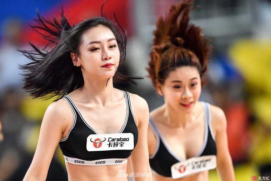 镜头拉近，一位篮球宝贝在暂停间隙奋力跃起，马尾辫在空中划出优美的弧线，脸上洋溢着灿烂自信的笑容，瞬间点燃了看台上观众的手机闪光灯