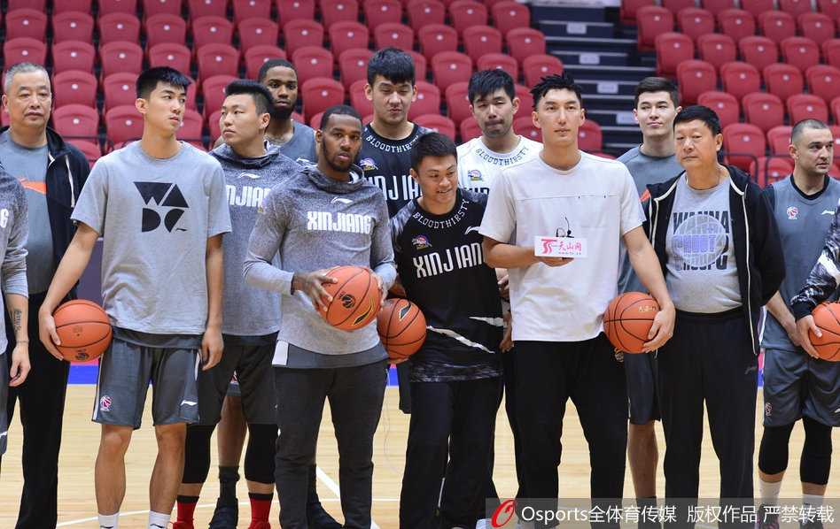 训练中肖恩朗弯腰与队友可兰白克击掌，两人手臂肌肉贲张，汗水在灯光下反光，更衣室气氛热烈而专注