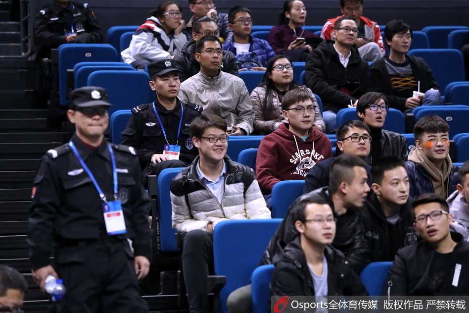 客场看台上一小片红色方阵格外醒目，中国球迷挥舞着五星红旗，在满场韩国观众的白色海洋中倔强挺立