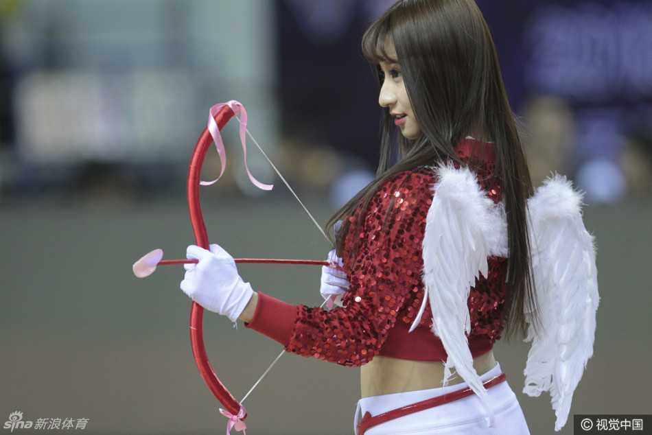 舞台中央，一位萌系装扮的“福女”手捧鲜花，对着镜头露出甜美笑容，并俏皮地比出剪刀手，显得既可爱又喜庆。