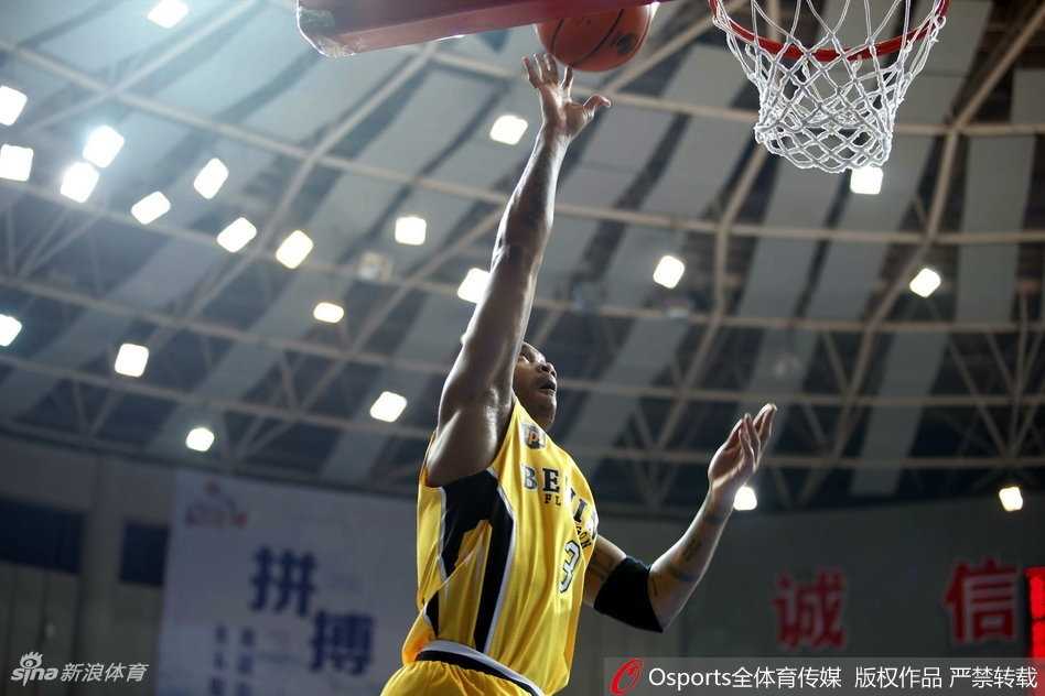 北控外援兰多夫顶着防守悍将强起上篮，肌肉线条在对抗中绷紧，展现出一股势在必得的强悍力量。