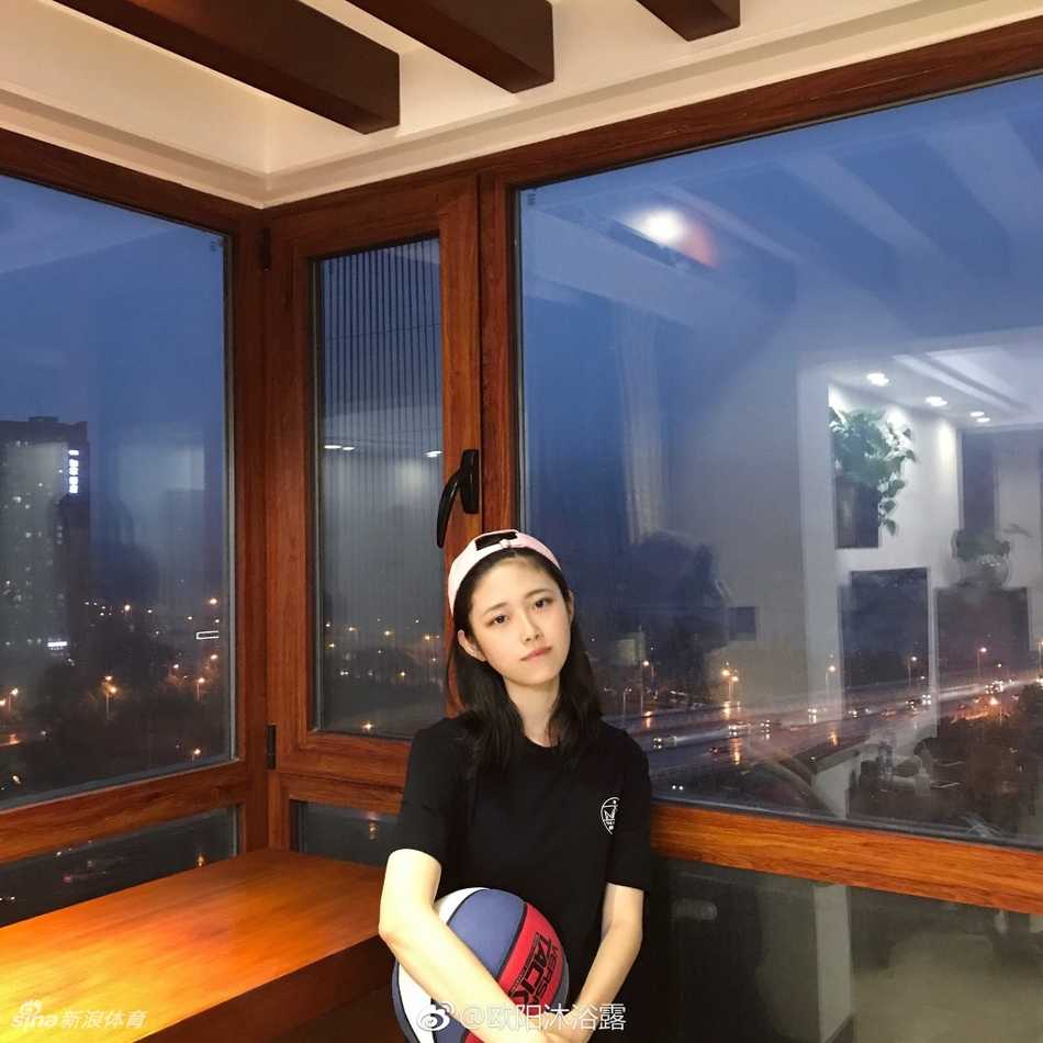 欧阳沐家中一角，她正欣赏着自己收藏的几双经典篮球鞋，其中不乏她最爱的AJ1和AJ6系列，体现了她对篮球文化的热爱。