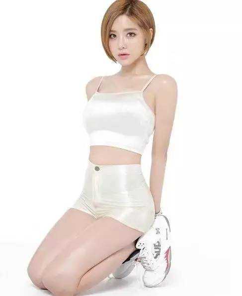 黄素熙坐在椅子上对着镜头露出甜美笑容，身后的背景墙挂满了潮流衣物，整个空间充满了年轻时尚的氛围