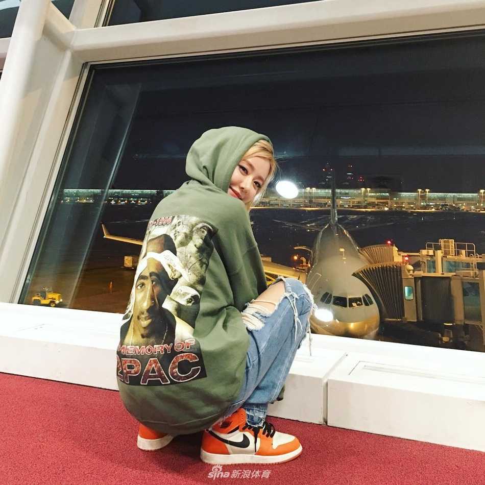 DJ Soda身穿紧身连衣裙，将一双Air Jordan球鞋抱在怀中，她低下头深情凝视着手中的鞋子，金色的头发遮住了半边脸，画面充满了女性魅力与对球鞋的温柔爱意。