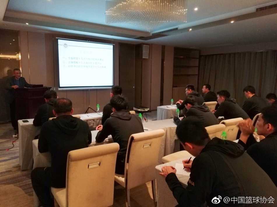 一名队员正在认真记笔记，笔记本上密密麻麻写满了听课心得，细节处展现了运动员对思想教育的重视