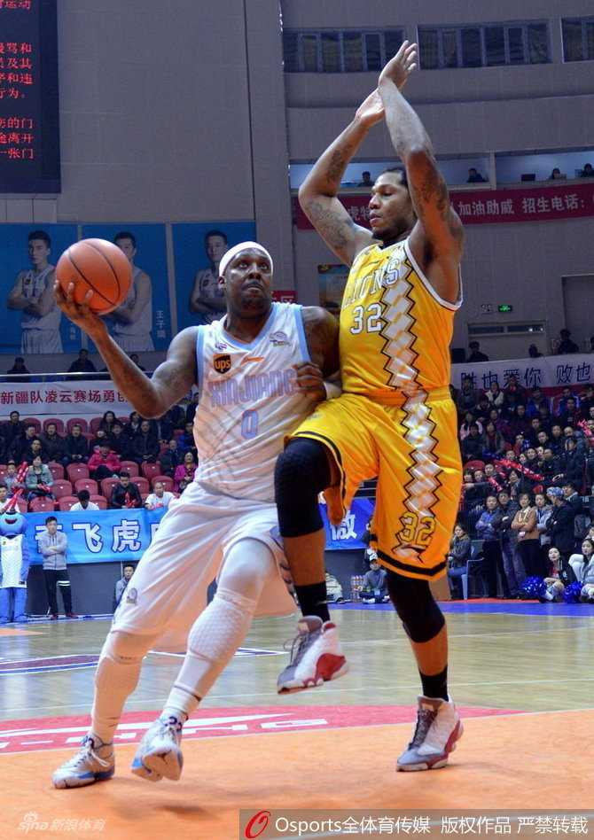 广厦发动机福特森如旋风般杀入敌阵，在新疆队三名防守球员的合围下强行突破，尽管身形受阻，但他依然奋力将球抛向篮筐，眼神中充满了不屈的斗志。