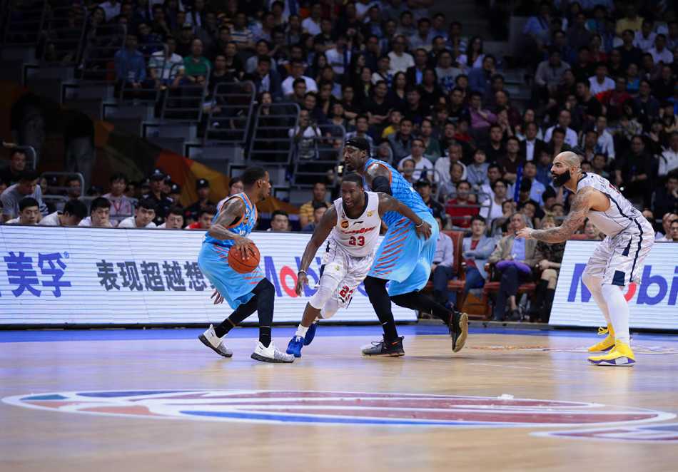 西热力江犹如一头雄狮，张开双臂死死缠住广东外援斯隆，寸步不让。