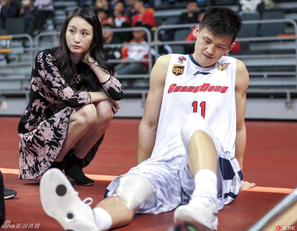 周琦的女友在观众席上微笑着挥手致意，她妆容精致，落落大方，面对镜头毫不怯场，用灿烂的笑容为场上的男友传递着无声的力量。
