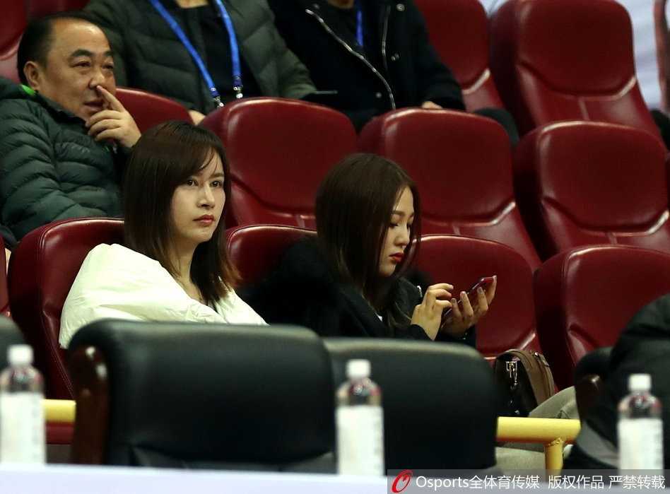 长发披肩的女生轻托下巴露出温婉的侧颜杀，球馆的灯光在她眼中化作点点星光，仿佛在看一场最动人的篮球电影。