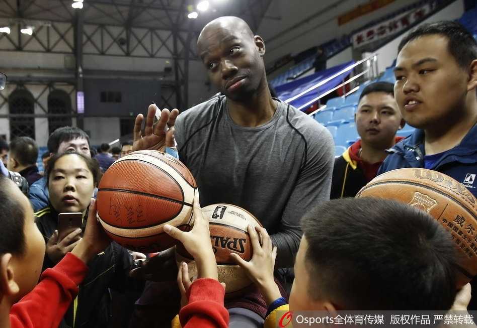 兰德里在球迷的簇拥下开怀大笑，露出标志性的大胡子，眼神里满是见到中国球迷的喜悦