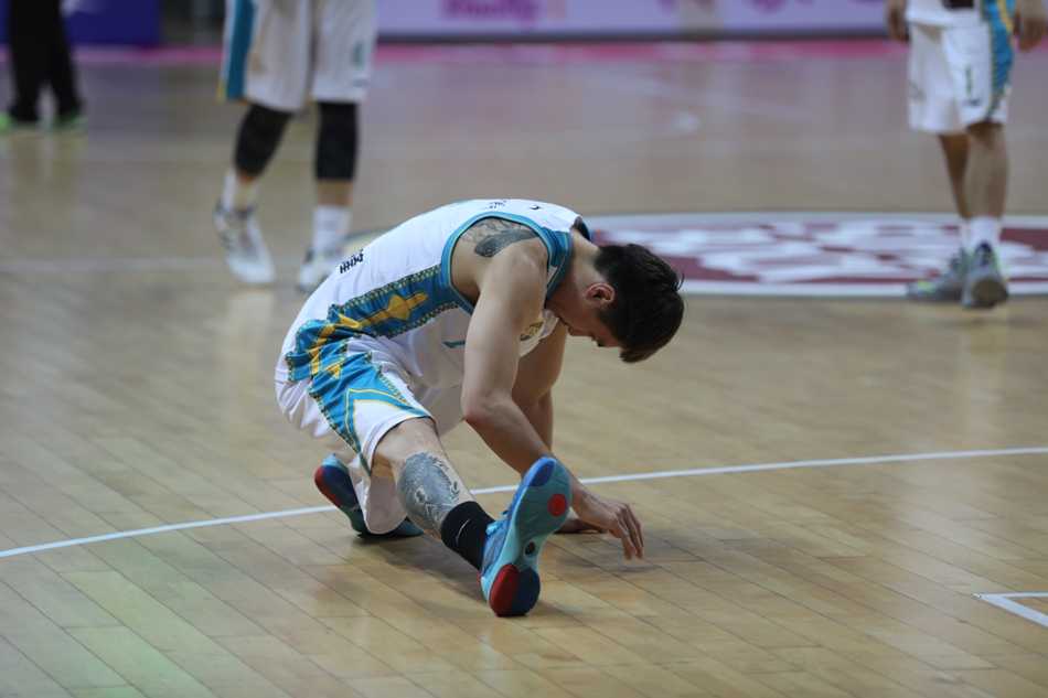 周启新如同猎豹一般紧贴对手，他张开双臂，眼神坚毅，脚下步伐迅捷，寸步不离地缠绕着美国队的持球核心。